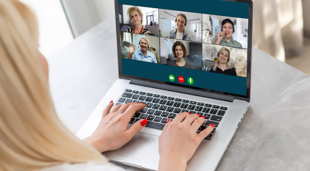 Real estate team virtual meeting across multiple states Real estate agent leading a virtual team meeting with agents from different states on a laptop