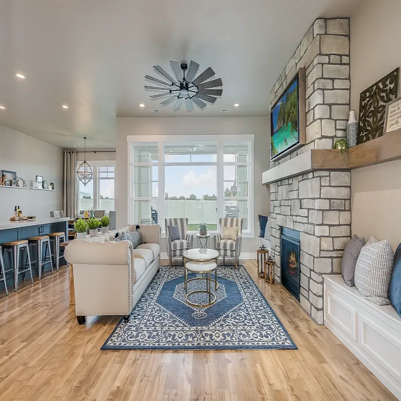 Living Room with Stone Fireplace and Blue Rug Modern living room with stone fireplace and large windows